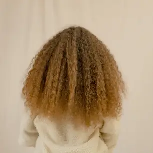 مراحل روتین روزانه برای مراقبت از موهای فر شامل اسپری، شانه و روغن سبک